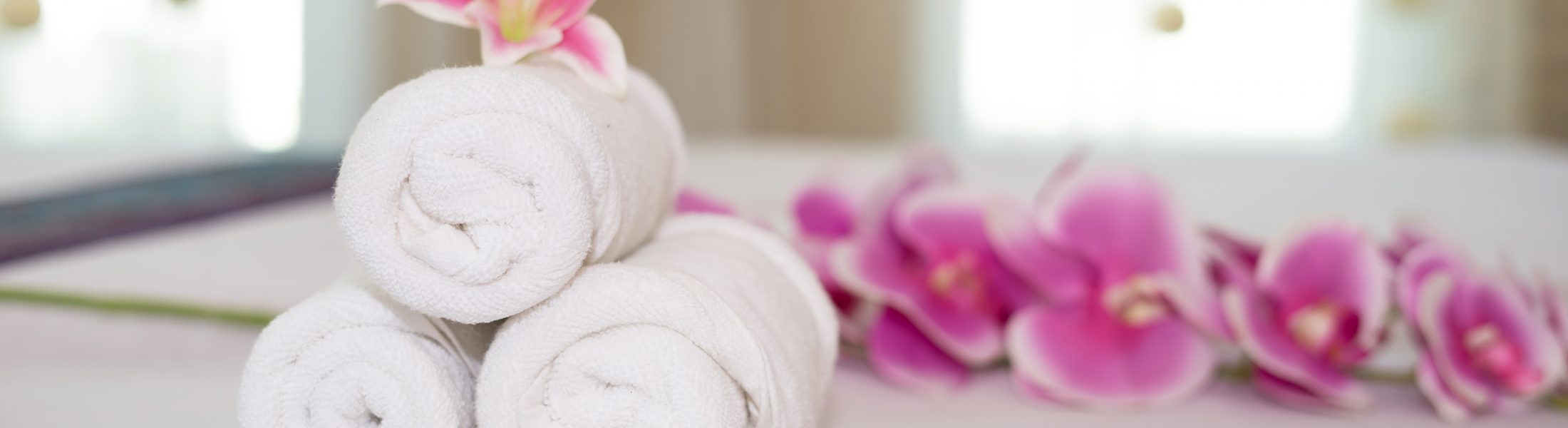 beautiful pink orchid on white towel in spa salon.