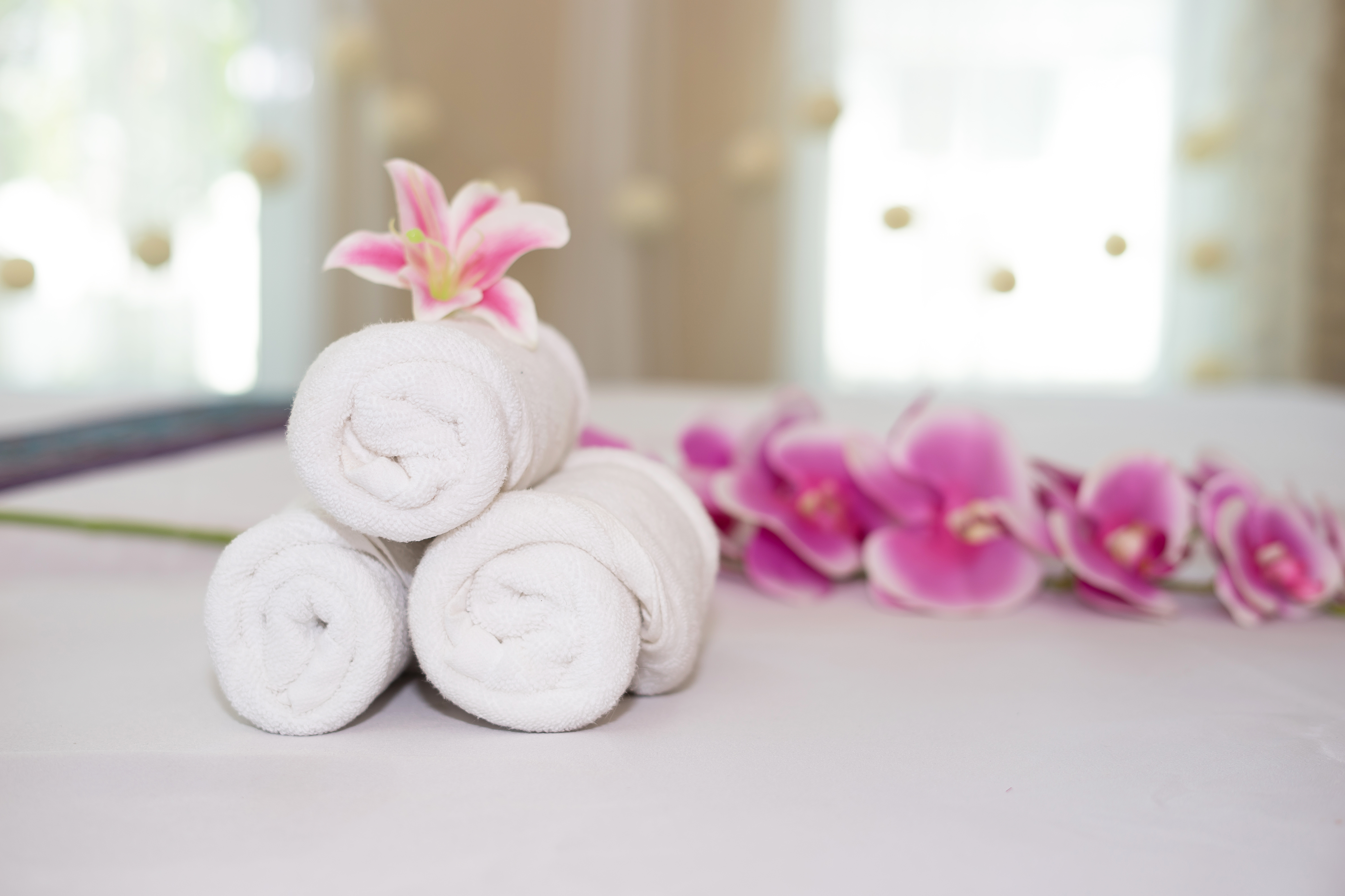 beautiful pink orchid on white towel in spa salon.